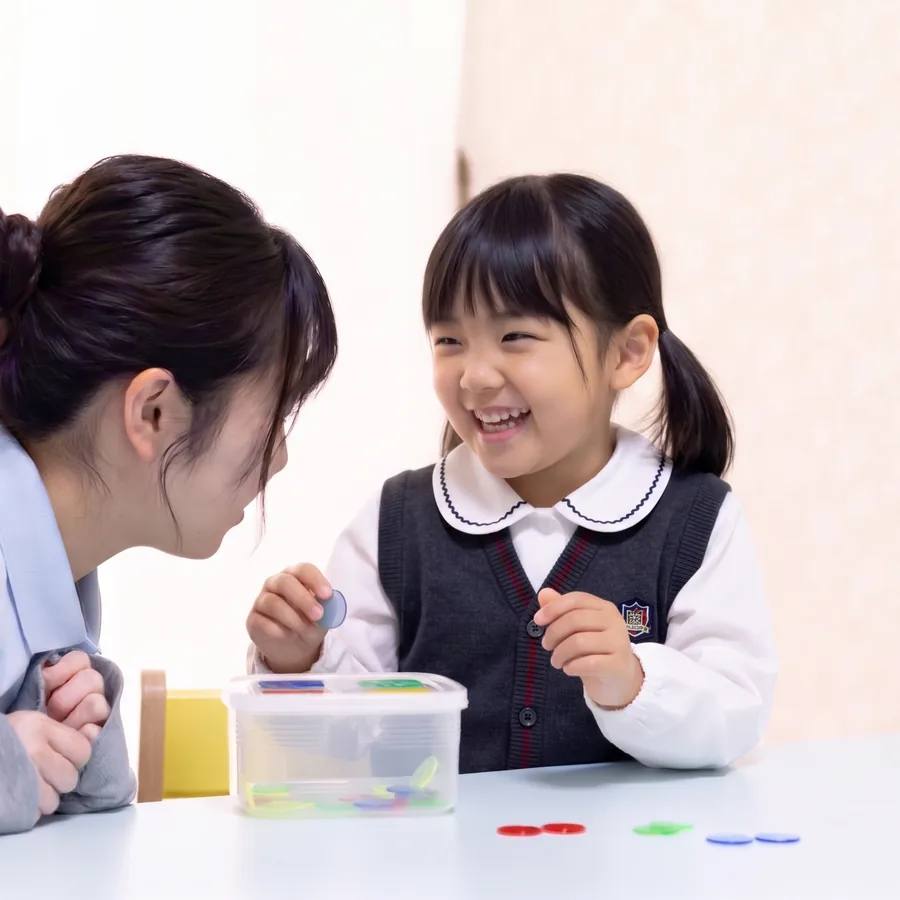 なな星の職員とお子さまが、おもちゃで一緒に遊びながら笑い合っている様子（イメージ画像）